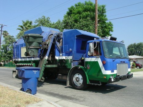 Construction workers loading a skip with debris